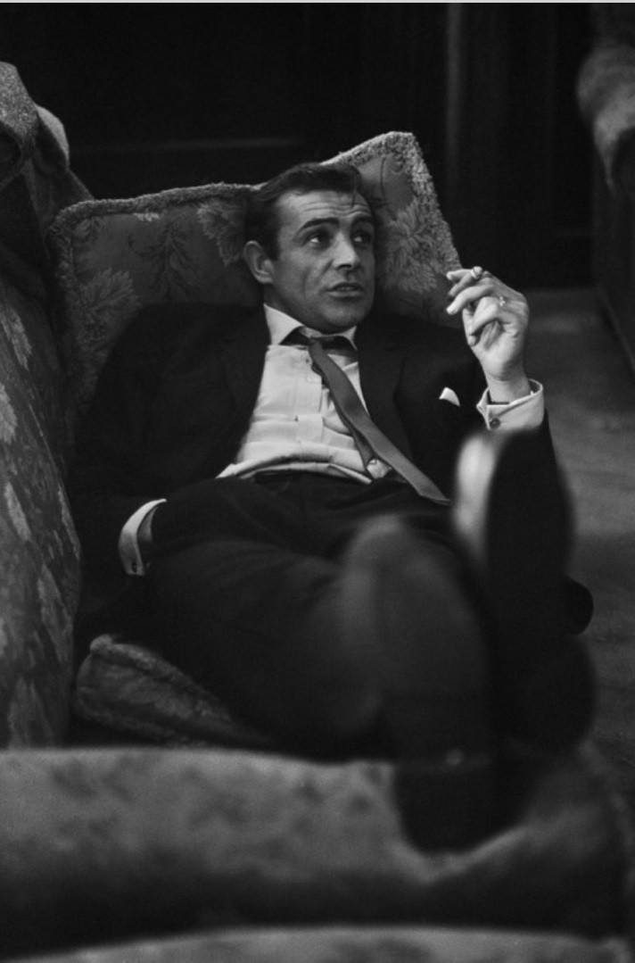 A young Sean Connery relaxing on the couch.