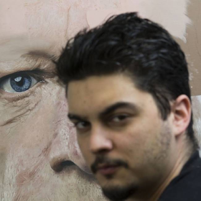 The artist posing in front of one of his works.