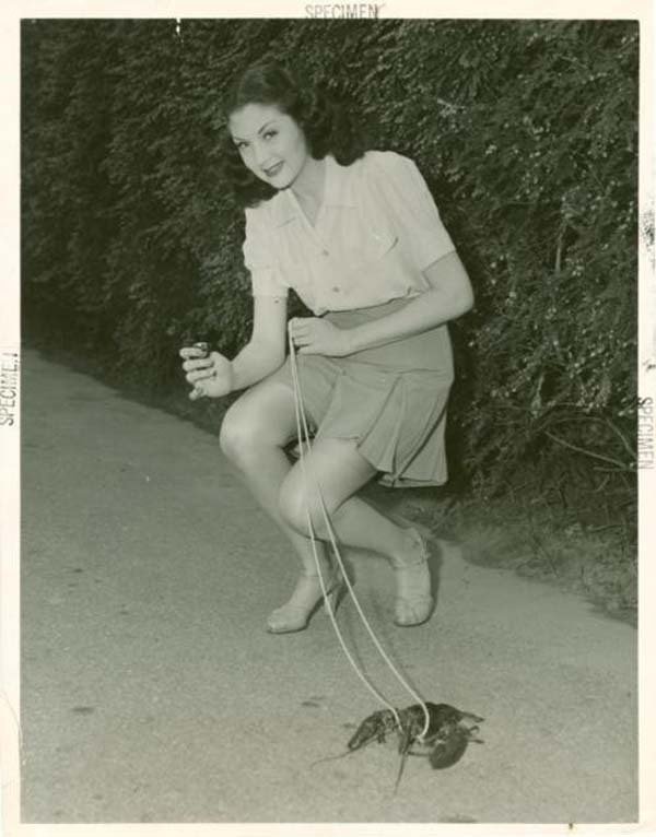 39.) A young woman takes her pet lobster out for a walk (1950s).