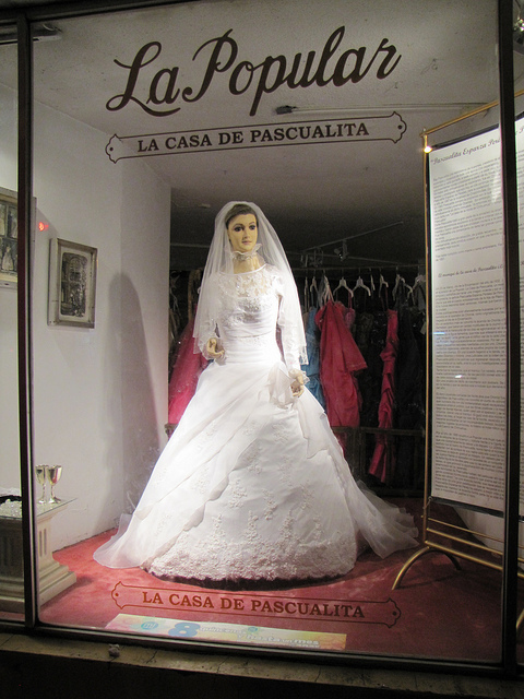 The mannequin is nick named La Pascualita or Little Pascuala. The owner at the time La Pascualita came to the store was Pascuala Esparza, hence the nick name.