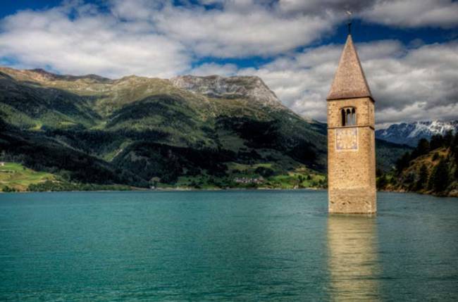 Without knowing the full story, you might be taken aback by the sight of a lone bell tower in the middle of a beautiful lake.