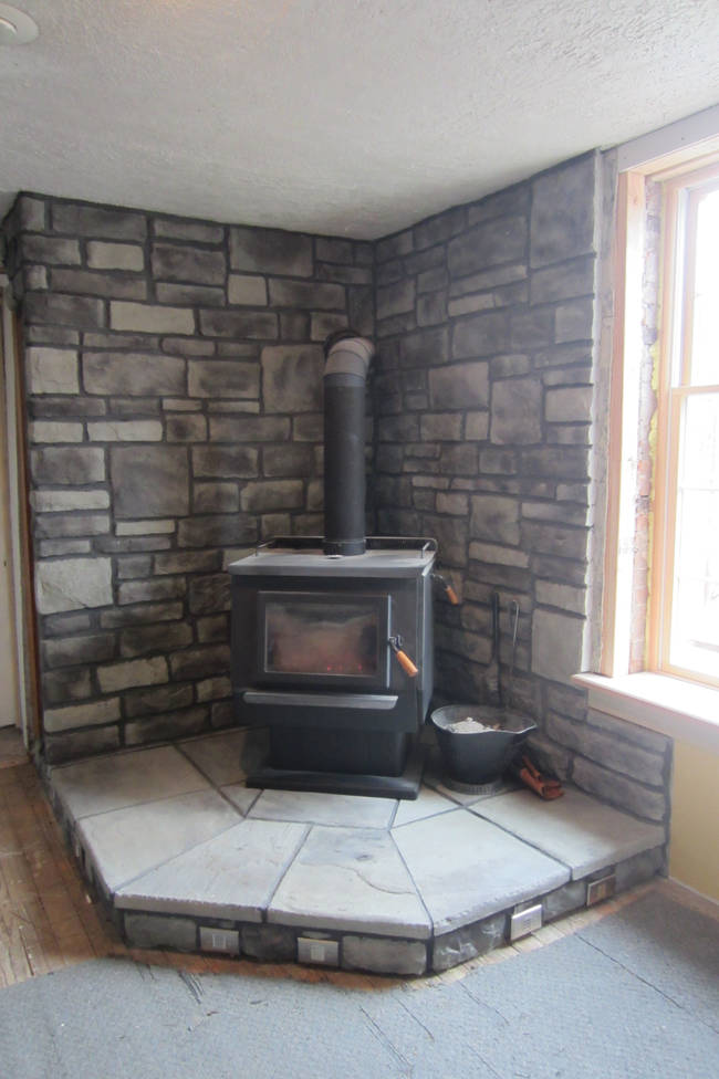 And here it is, all installed and ready to start warming the place up. As a bonus, he constructed a space behind the left wall to keep firewood for easy access!