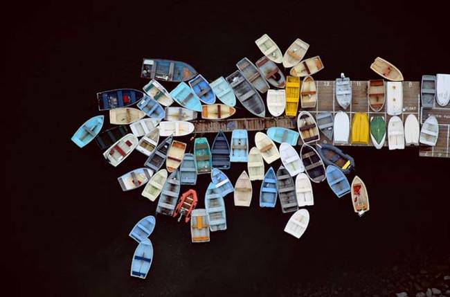 Boats all gathered around a dock.