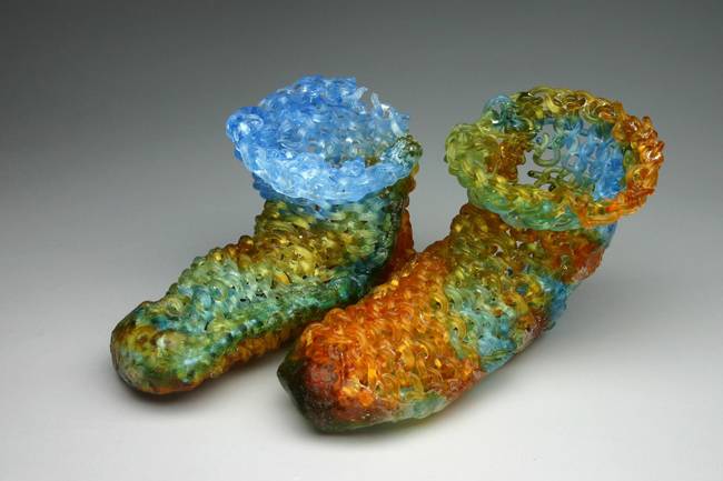 The sculptures sometimes take on the shapes of knitted items, like these booties.