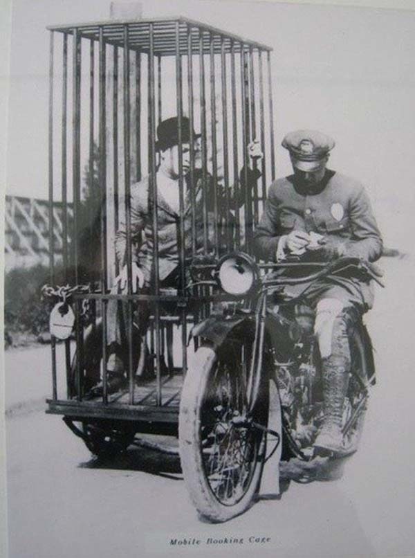 7.) A police officer on a Harley-Davidson transports a prisoner in a holding cell (1921).