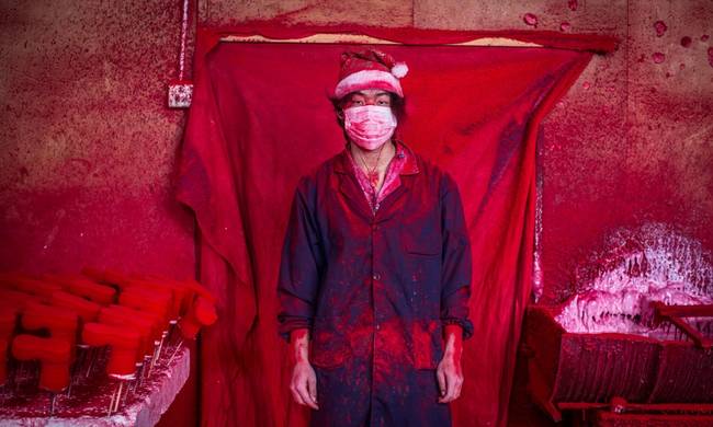 This is Wei. He and his father work at taking polystyrene snowflakes and putting them in a powder-coating machine until they turn red. The powder apparently gets everywhere.