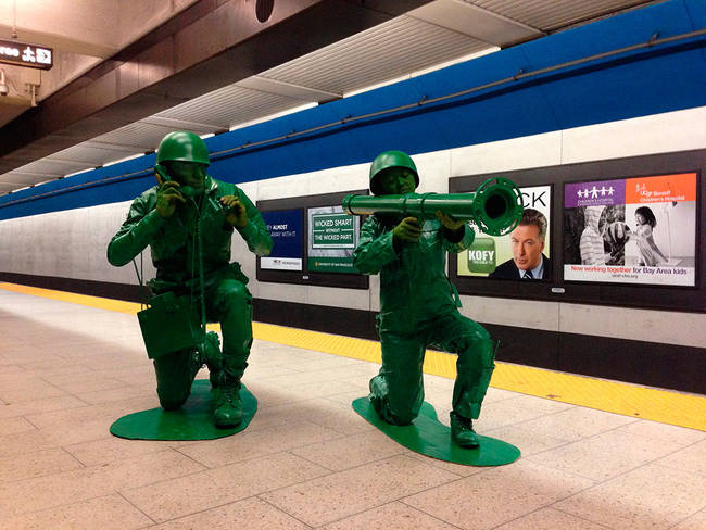 Two army soldiers casually waiting for their train to arrive.