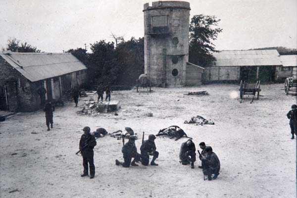 US troops make plans while hiding out at a farm near Utah Beach, surrounded by slain cattle.