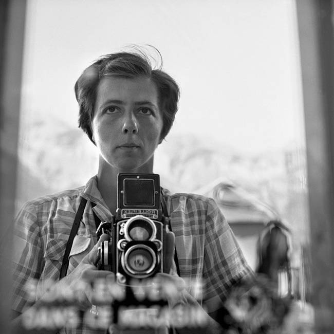 A "selfie" taken in a reflection, showing not only Vivian Maier, but her camera.