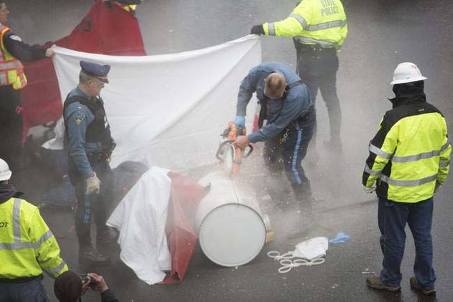 Police and emergency responders had to use a heavy saw to cut through the barrel. They used the jaws of life to remove the protestors from the 1,200 pound barrel.