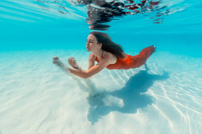 The sunlight bursts through the waves to light up her serene face.