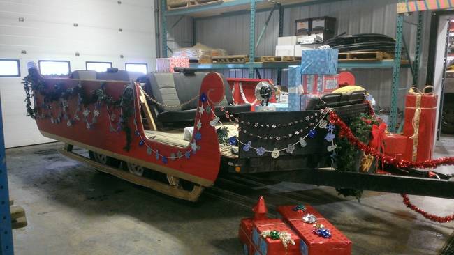 Finally, the best part! He painted the exterior of the sleigh red, added tinsel, lights, and wreaths to complete the festive look.