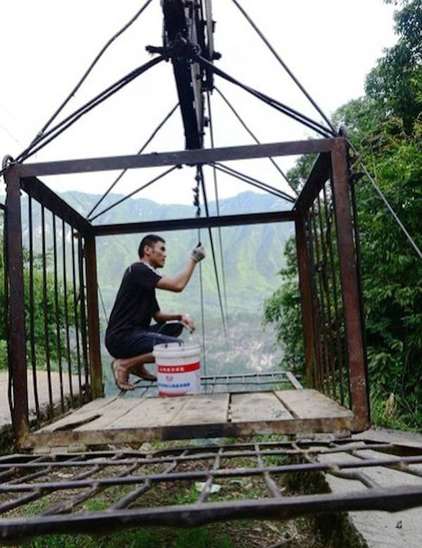 Yushan resident lubricating the wire to keep things running smoothly.