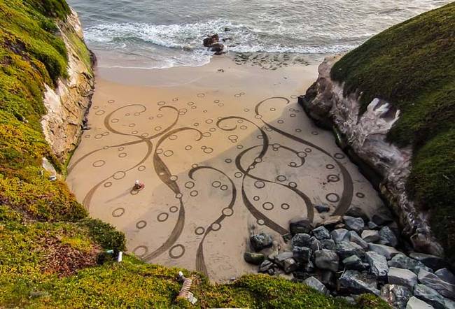 He flies the camera high above the beach so he can take photographs of his finished work.