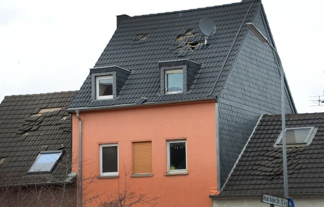 Damage to a nearby house.