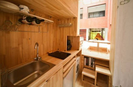 There's also a full kitchen with a sink, stove, and oven. The area is also equipped with a dishwasher and washing machine.