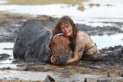 11.) A woman helping a horse who got stuck in mud.