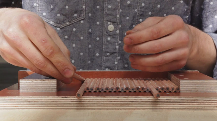 First, he glues the pencils to a sheet.