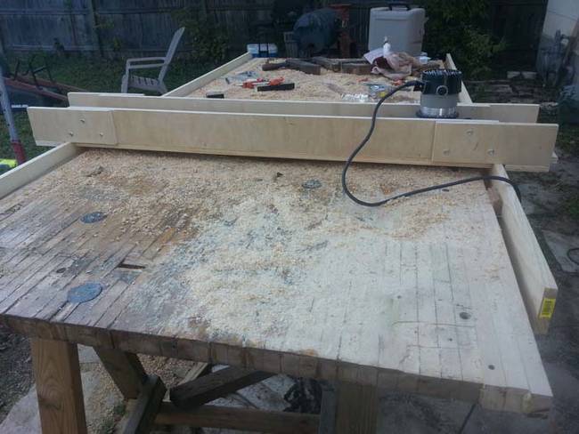 The table was difficult to sand, so he used a router sled to assist him. It holds the sander in place and slides down the surface.