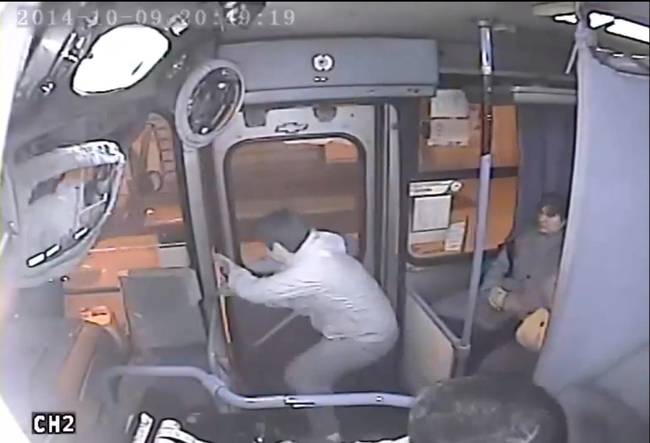 He gives up on the purse and tries to escape, but the door is almost completely closed and the bus has started moving. He and his accomplice can't keep the door open.