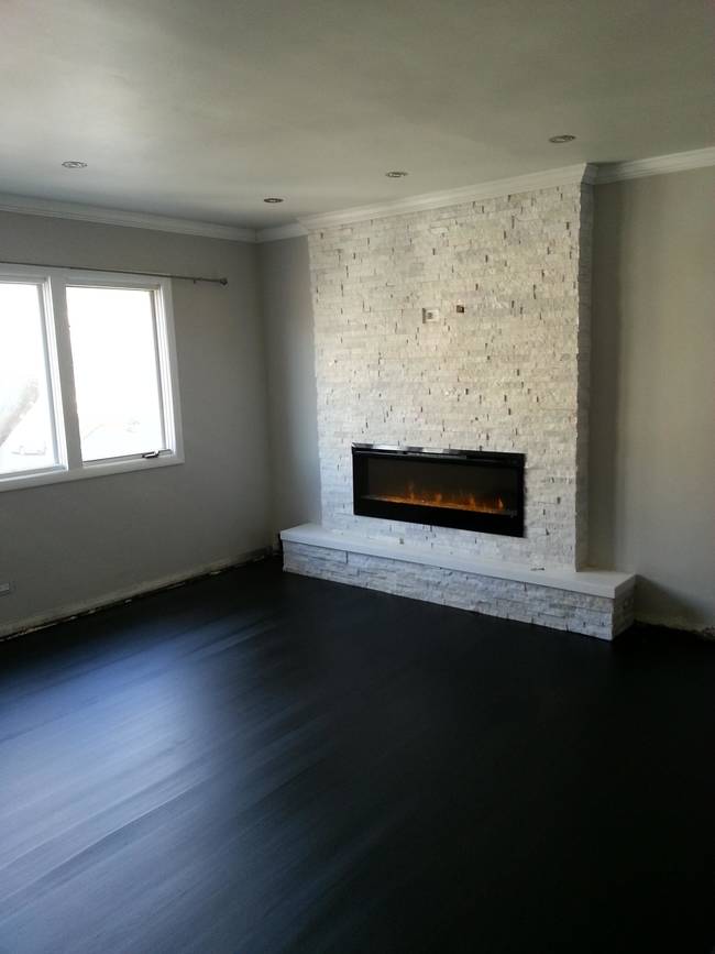 The dark hardwood flooring! It provides the perfect contrast to the light stone on the hearth.