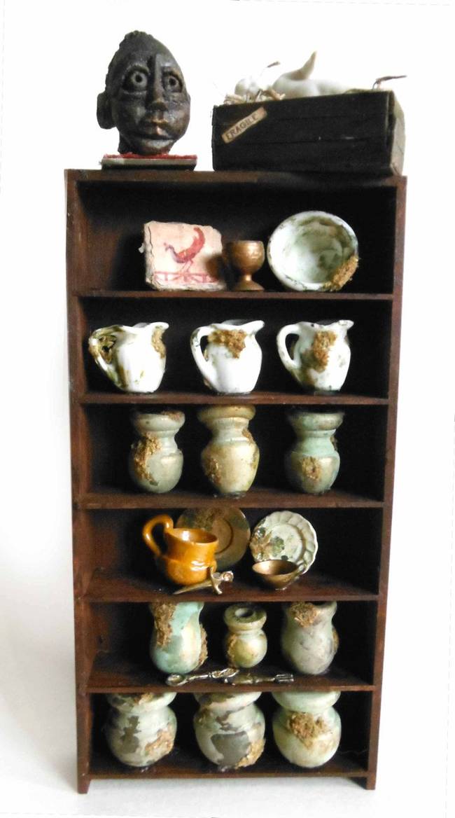 A mini curio cabinet full of pottery.