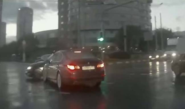 A car appears out of nowhere, pulling in front of the black BMW and nearly causing an accident.