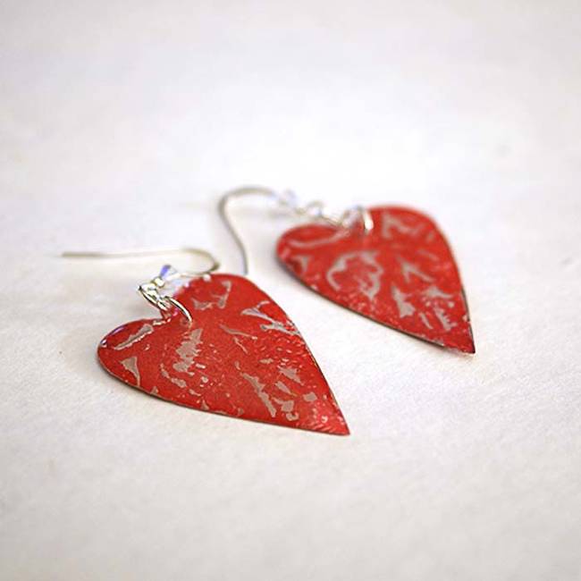 Aluminum cans become heart shaped earrings with a few quick snips and a coat of red paint.