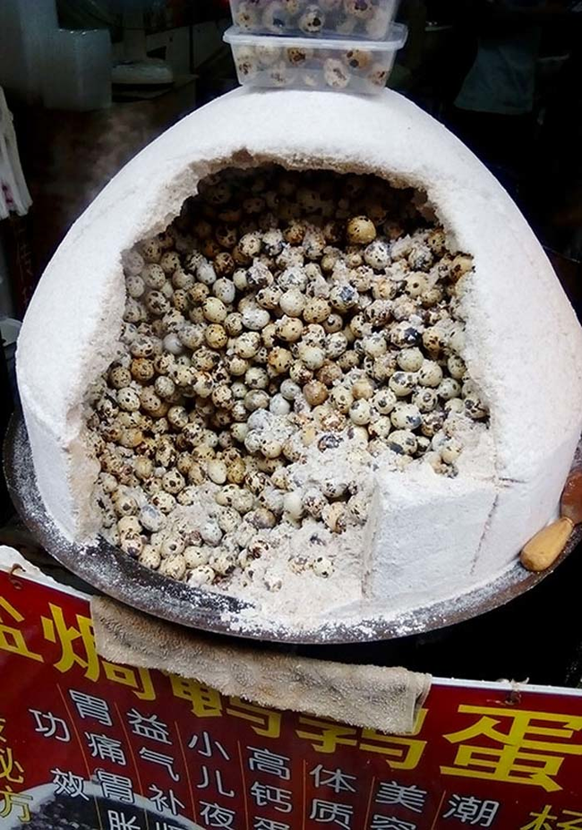 A huge chunk of salt is hollowed out, filled with hundreds of quail eggs. Then, this big cooker salts and cooks them through at the same time.