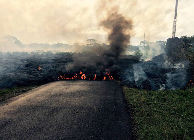 The flow of lava in this photo is moving from right to left across a road.