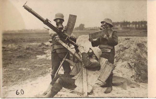 32.) Three German soldiers in body armor and gas masks demonstrate operating a 2cm Becker-Flugzeugkanone, an anti-aircraft gun, Western Front (1918).