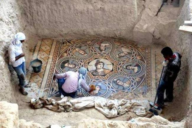 Archaeologists at work in Zeugma, Turkey. The mosaic they're in the middle of uncovering shows the nine Muses.