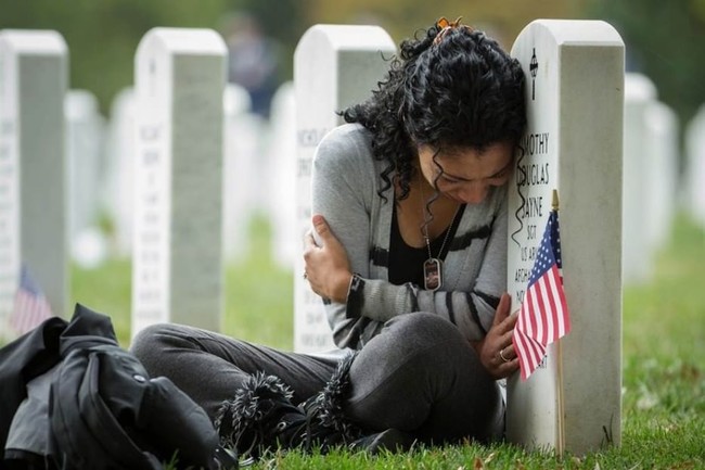 7.) Thania Sayne leaning on her husband's headstone the day before their wedding anniversary.