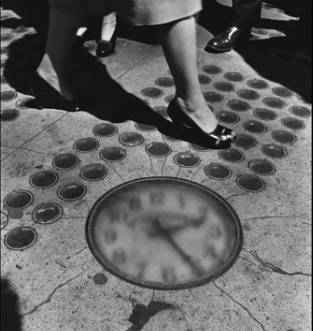 The clock in the 1940s, when it still had Arabic numbers. It also lacked the frame it has today, and note how the sidewalk has been replaced and the little skylights no longer exist.