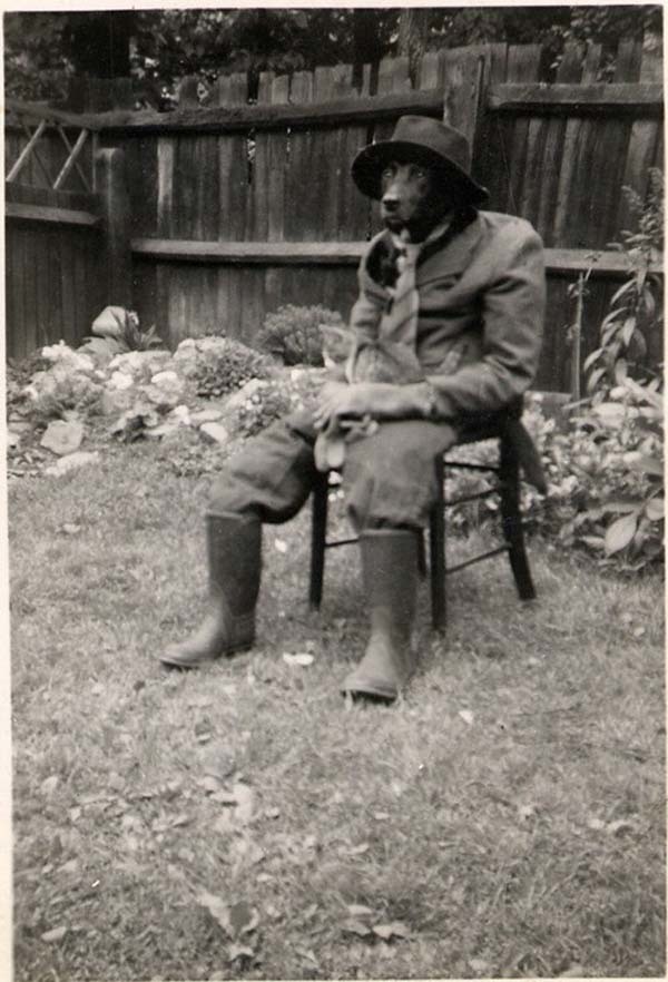 30.) A man dresses his dog up in a suit and puts his cat in the dog's lap for a picture (1950s).