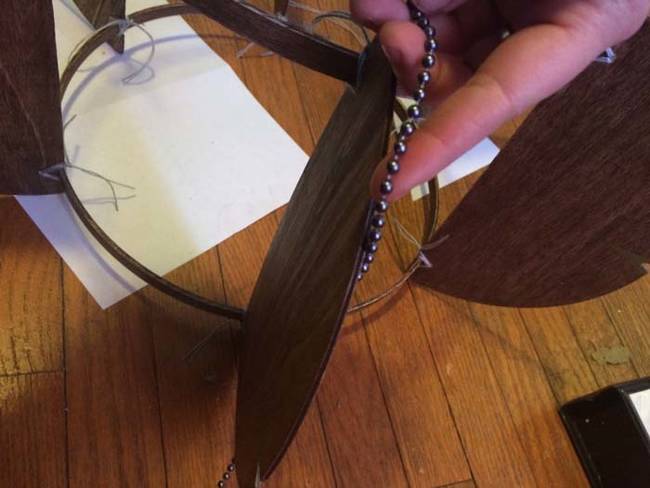 She measured out the lengths of beading for the edges of the wood circle halves. The beads act as teeth to hold the string in place.