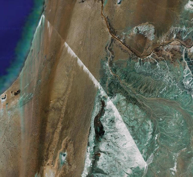 It's so long that the belt is visible as a straight line in satellite photos, and at some places, easily recognizable by a white strip of phosphates that get blown off the belt due to big Saharan winds.