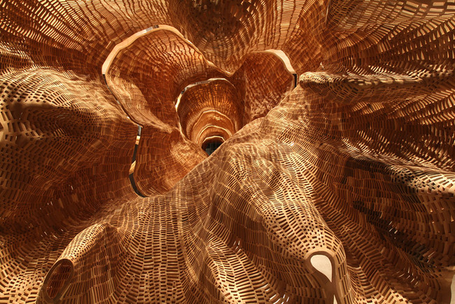 The lattice-like wood block arrangement gives the familiar form of the tree a new texture and allows light to come through it, making its shape seem different and new.