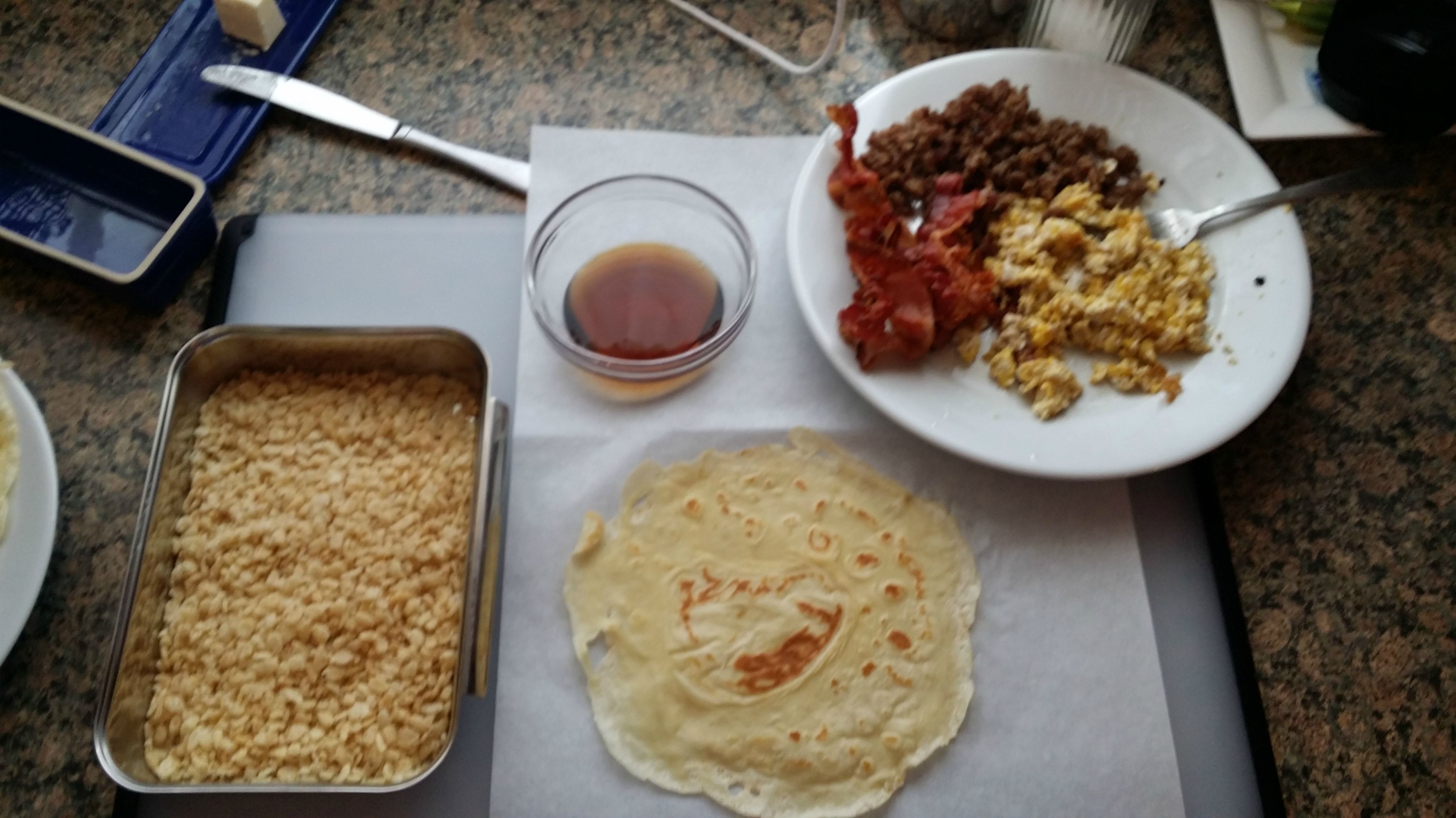 Eggs, bacon, sausage, crepe (pancake), and rice krispies.