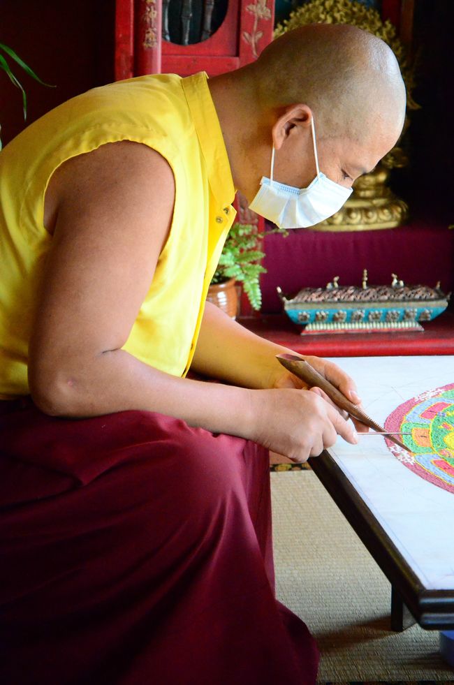 Make sure not to sneeze. The monks wear masks to keep from breathing directly on the Mandala.