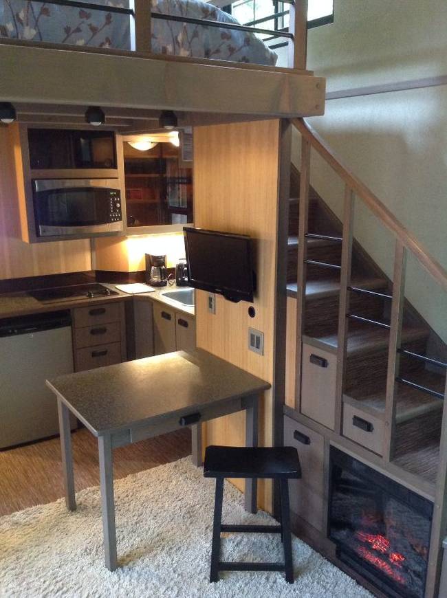 The kitchen and dining area are just a few steps away from the stairs leading up to the bedroom.