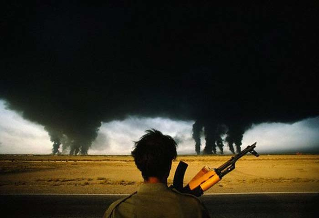 8.) 1990 - Iranian soldiers looks at the burning Iraqi oil fields.