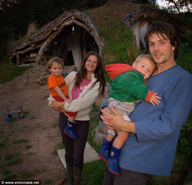 Simon Dale and his family outside of their Hobbit house.