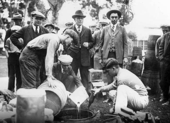 8.) Police pouring out illegal booze during prohibition in 1925.