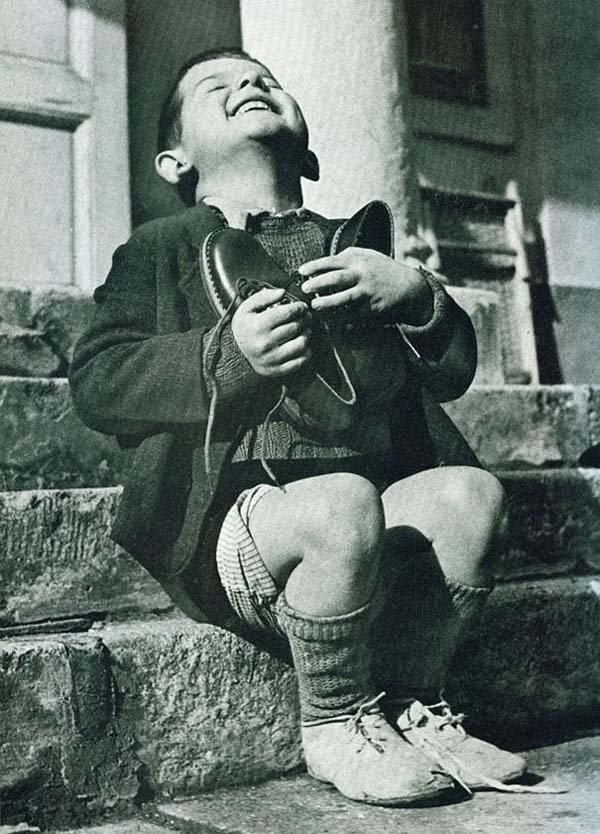 28.) An Austrian boy is excited about his first pair of new shoes in years (1946).