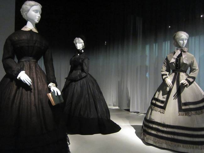 The gray gown on the right is actually a wedding gown, made just after the Civil War. While the bride had not, apparently, experienced a loss personally, the tragic state of the country made her wedding a relatively somber affair. At this point, the pervasiveness of death was so absolute that even weddings were tinged with it. The whole country was in mourning.