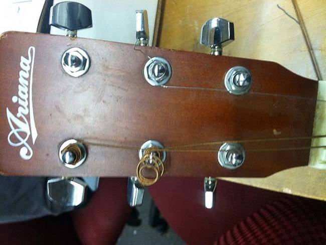 First, remove the strings from the guitar by loosening the tuning machine.