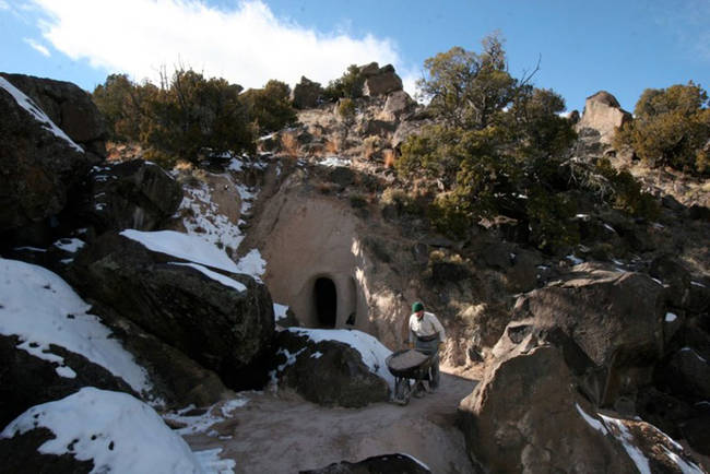 Paulette carts the rocks and dirt out by hand, through the inconspicuous, but mysterious-looking entrance to the cave.