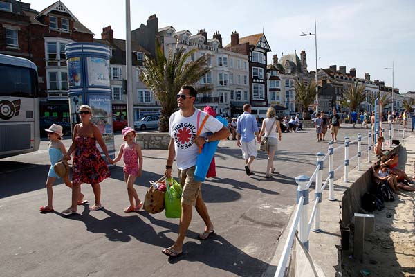 Tourists walk along the beach-front at this port that was a departure point for thousands of Allied troops.