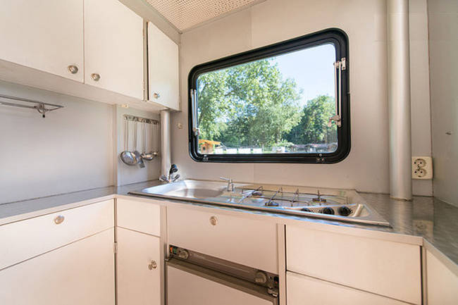 Inside, it resembles a small apartment more than a camper, with kitchen appliances, seating, and electrical capability. 